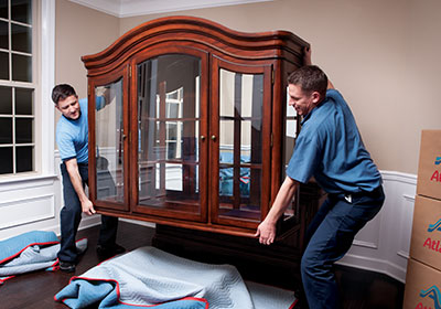 Antique movers packing a cabinet